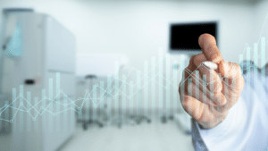 Hand reaching toward a blank screen with a blurred data chart in the background