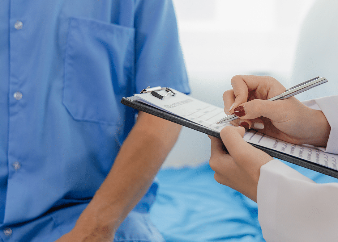 Close-up of a doctor writing on a clipboard
