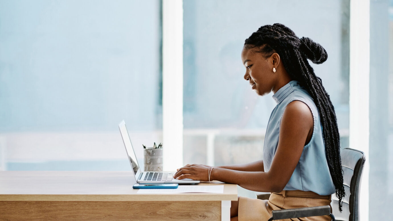 Young businesswoman working on a laptop in an office alone
