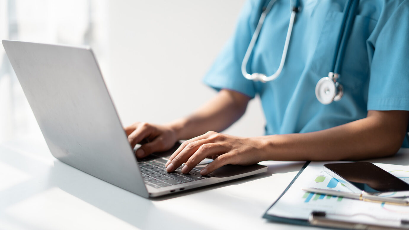 doctor on a laptop utilizing clinical data management services