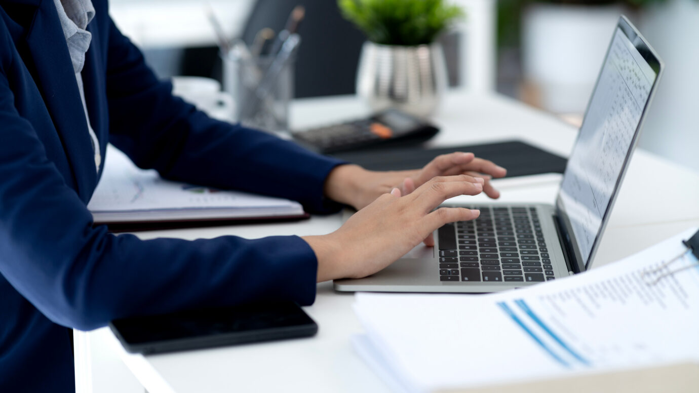 Young business woman is typing data using a computer to do business in the office alone.
